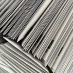 Blick von oben auf einen Wäschekorb voller weißer Briefumschläge