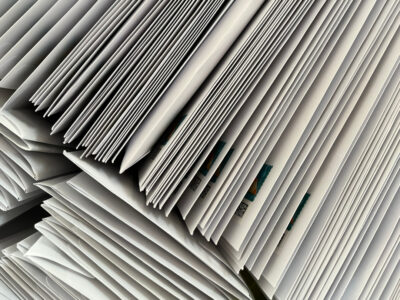 Blick von oben auf einen Wäschekorb voller weißer Briefumschläge